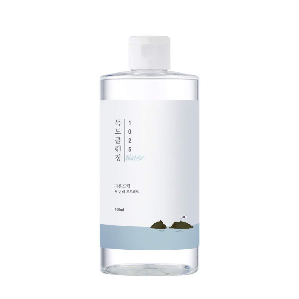ROUND LAB 1025 Dokdo Cleansing Water bottle with blue cleansing water against a bubbly water background