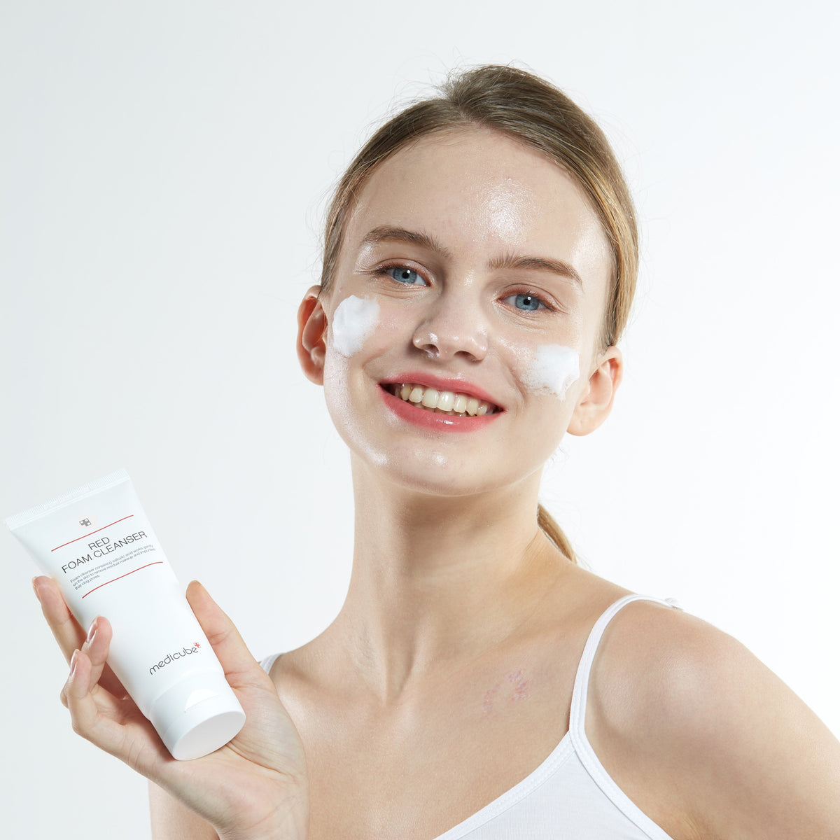 Medicube Red Foam Cleanser 120 ml white tube displayed against a cushion of white foam